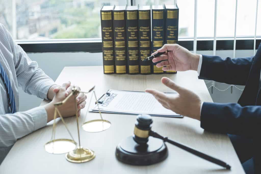 Lawyer hand holding pen and providing legal consult business dispute service at the office