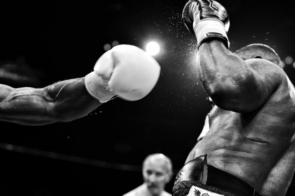 Boxing glove punching another person used for unlawful assault